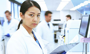Female lab technician stands in a busy laboratory.